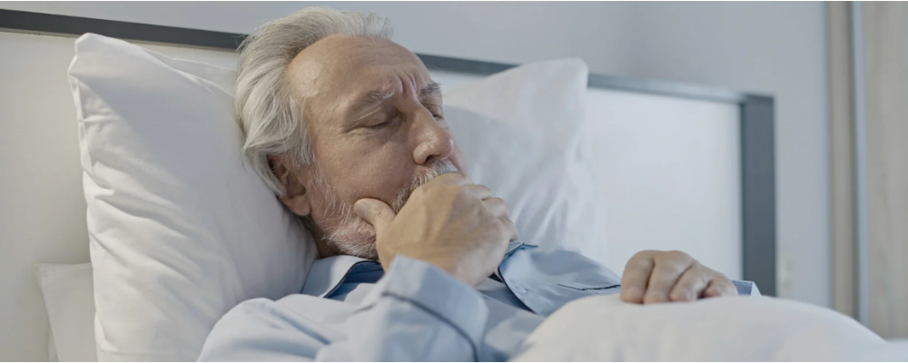 Close-up view of a modern mucus suction machine used in respiratory care, placed on a medical trolley in a clinical setting.